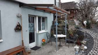 Separater Eingang zum Studio in Eschen mit überdachtem Zugang und dekorativen Elementen.