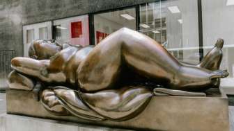 Üppige Frauenfigur aus Bronze – das Kunstwerk „Reclining Woman“ von Fernando Botero als Blickfang in der Innenstadt.