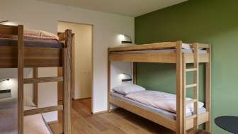 Vierbettzimmer mit Etagenbetten und Holzboden in der Jugendherberge Schaan-Vaduz