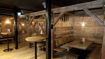 Gemütlicher Sitzbereich mit Holzbänken und Tischen im traditionellen Stil des Malbuner Lädeli