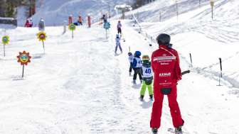 Skilehrperson und Kinder auf dem Sessellift im malbi-park