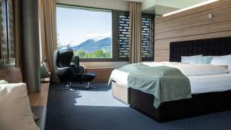 Modernes Doppelzimmer mit Aussicht auf die Berge im Grand Casino Hotel Liechtenstein