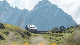 Blick auf die Pfälzerhütte mit Bergkulisse im Hintergrund