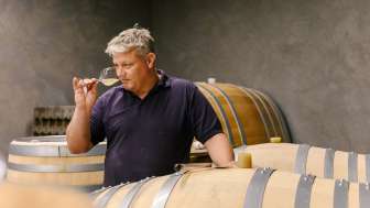 Winzer vom Weingut Hoop in Liechtenstein beim Verkosten des Weins direkt aus dem Holzfass im Weinkeller.