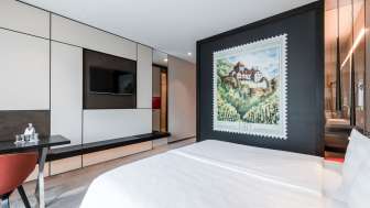 Aussenansicht des b_smart hotel mit Teich im Vordergrund