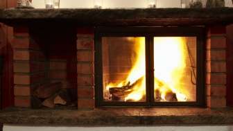 Warmer Kamin mit brennendem Holz und stimmungsvollem Licht