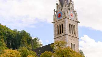 Blick auf den Turm der Kathedrale St. Florin mit Bäumen im Vordergrund