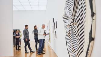 Besuchergruppe im Ausstellungsraum des Kunstmuseums, im Vordergrund ein grosses, rundes Kunstwerk