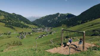 Eine Familie geniesst das gemeinsame Schaukeln auf dem Schaukelpfad in Malbun