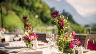 Gedeckter Tisch mit Blumendekoration auf der Terrasse des Restaurants