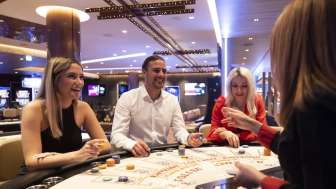 Freundliche Atmosphäre am Spieltisch: Drei Gäste unterhalten sich mit der Croupière im stilvoll eingerichteten Casino Schaanwald.