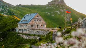 Pfälzerhütte mit Liechtenstein-Flagge bei Abendstimmung