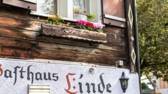Gasthaus Linde mit rustikaler Holzfassade und Blumen auf der Fensterbank