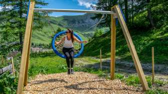 Eine Frau schaukelt in der Liechtensteiner Bergwelt und geniesst die Aussicht