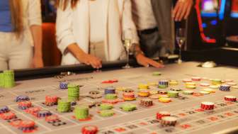 Gäste am Spieltisch beim Setzen ihrer Jetons im Casino Admiral Triesen, umgeben von spannender Casino-Atmosphäre.