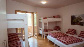 Familienfreundliches Mehrbettzimmer mit Etagenbetten und Einzelbetten im Gästehaus beim Camping Mittagsspitze.