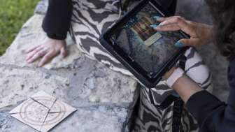 Spielerin verwendet iPad zur Rätsellösung beim Outdoor Adventure Room