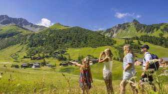 Familie blickt in die sommerliche Berglandschaft des Bergorts Malbun