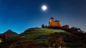 Burg Gutenberg bei Nacht unter Vollmond, eingebettet in die Weinberge