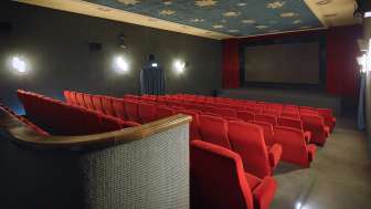 Seitlicher Blick in den Kinosaal des Alten Kino Vaduz mit roten Sesseln und atmosphärischer Beleuchtung.